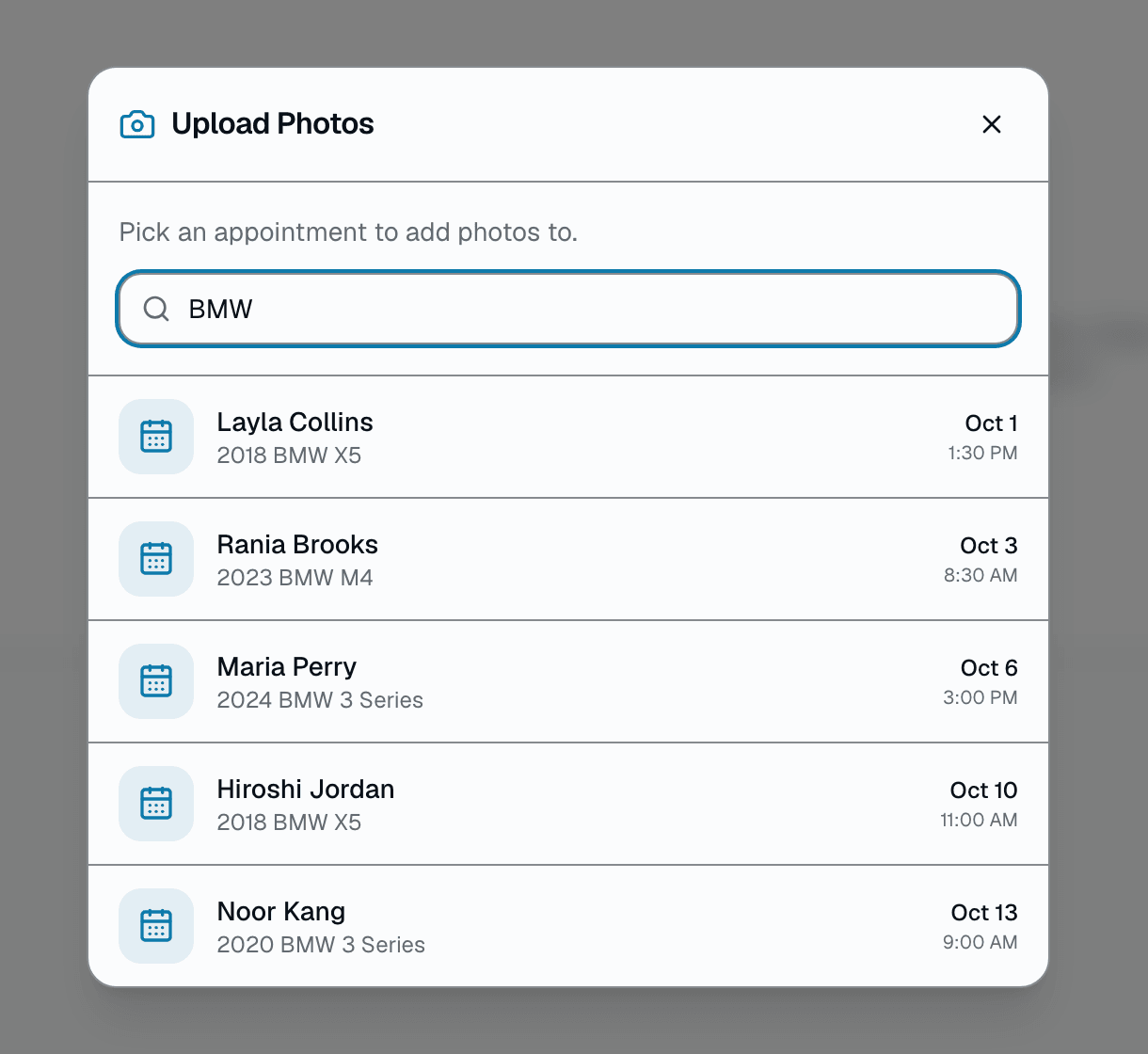 In /app/photos, open Upload Photos and type a customer's name or a vehicle year/make/model — it lists matching appointments from the last 14 days and next 7 — click one to open that appointment's own before/after/damage gallery. It's a text search across your shop's own photos, not a VIN or license-plate lookup, and there's no combined multi-visit timeline, quality-trend chart, or PDF export today — each visit's gallery is its own page..