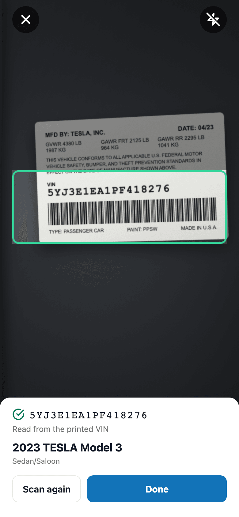The VIN label lined up in the frame, the read checked, and NHTSA's answer underneath: 2023 Tesla Model 3, Sedan.